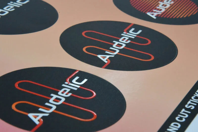 Round die-cut logo stickers printed on a sticker sheet
