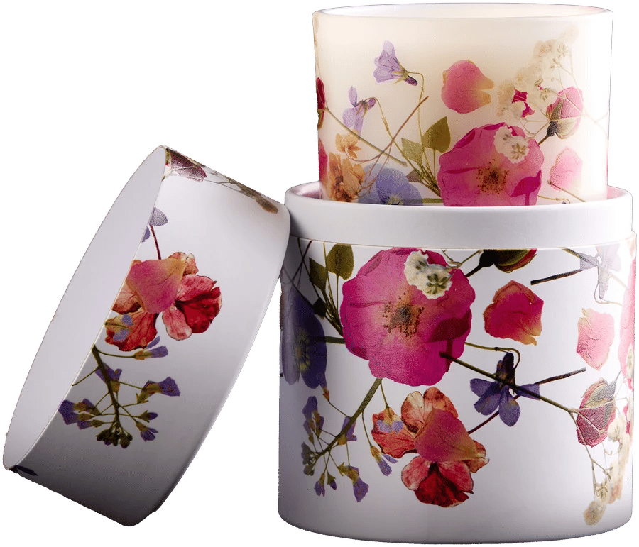 Vela en vaso de vidrio y estuche de papel con flores impresas