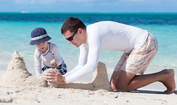 Diseñador en la playa con niño