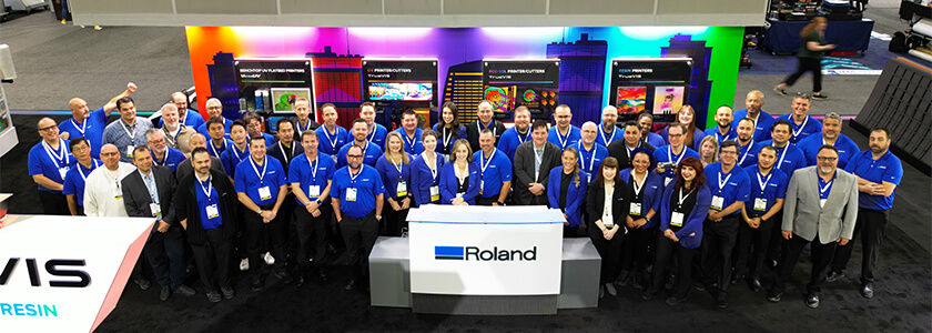 Roland DGA team members in front of the Roland DG booth at PRINTING United