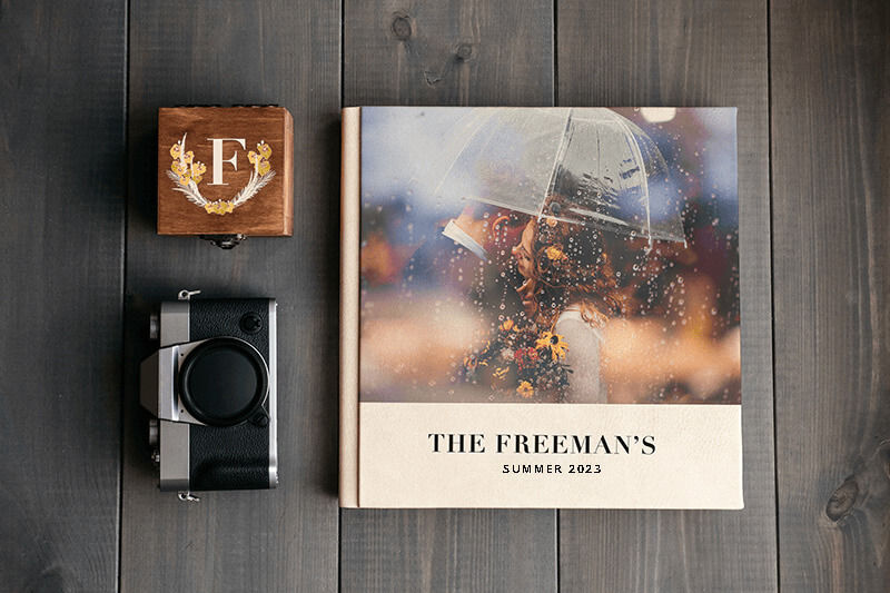 Posavasos, cámara y álbum de fotos sobre una superficie de madera.