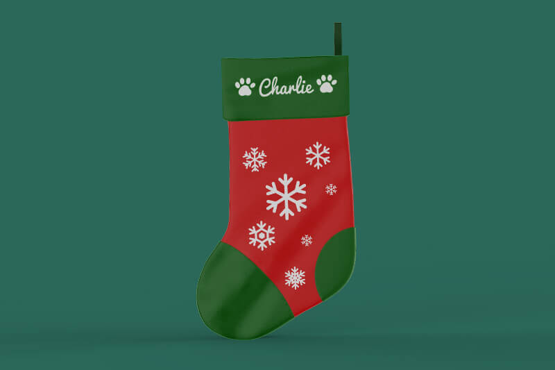 Red and green holiday stocking with pawprints and the name Charlie