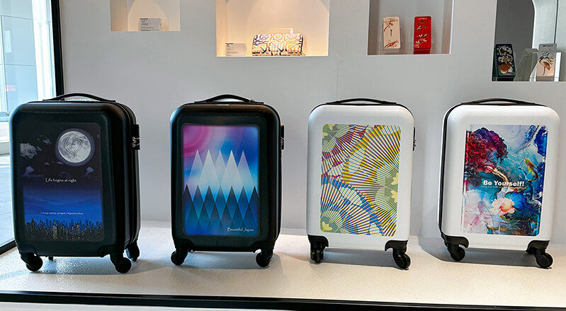 Cuatro maletas impresas con tecnología UV, cada una con diferentes gráficos personalizados