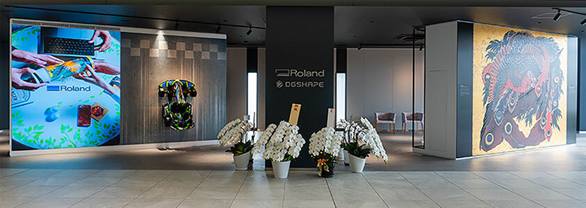 Vista de la entrada de la sede central de Roland DG con muestras de obras de arte y proyectos creados usando la tecnología digital Roland DG.