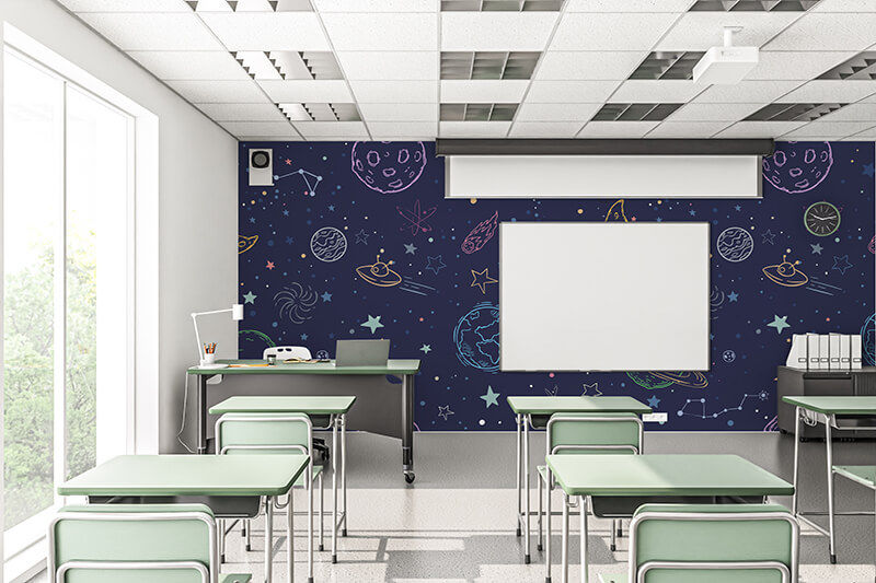 Classroom with student desks facing a wall with graphics of outer space on a deep blue background.