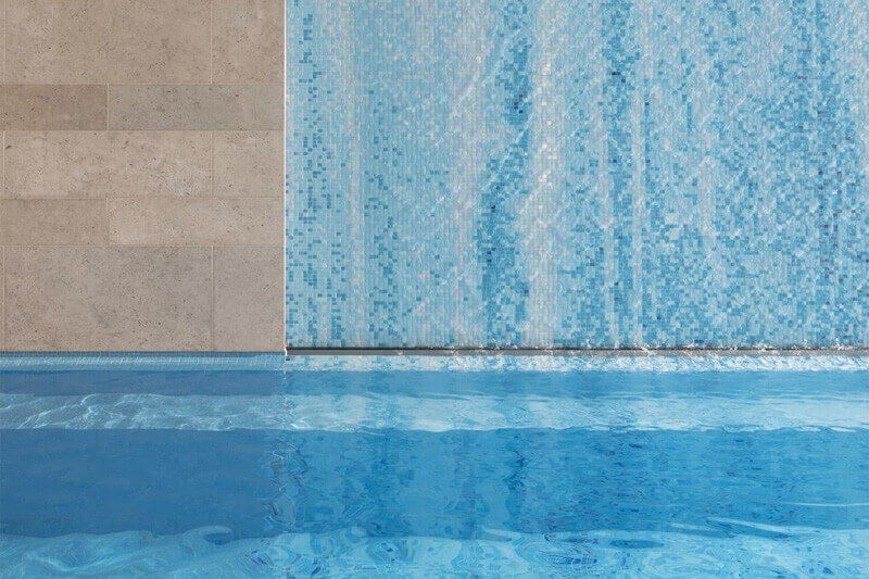 Pool with mosaic wall in the background.