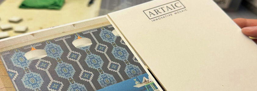 Hand holding sample card with photorealistic image of a mosaic with space on the other side for tile samples.