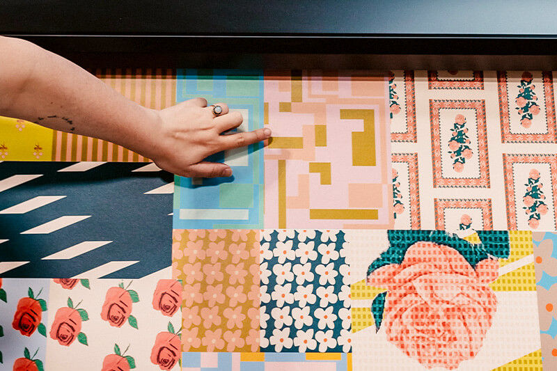 Hand pointing to design on print out of Bridget Thompson Studios' designs coming off the Roland DG printer.