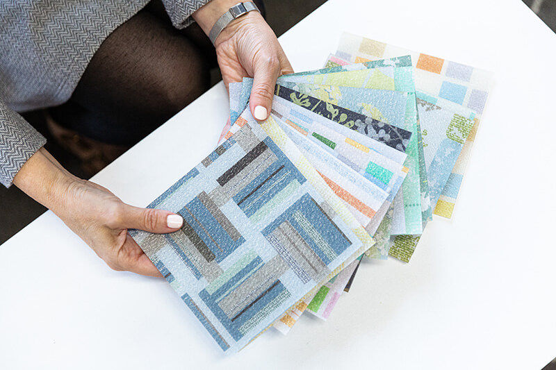 Hands holding squares of pattern samples