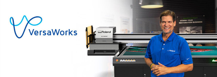 Roland DGA's Jay Roberts in front of the EU-1000MF flatbed UV printer with the VersaWorks logo.