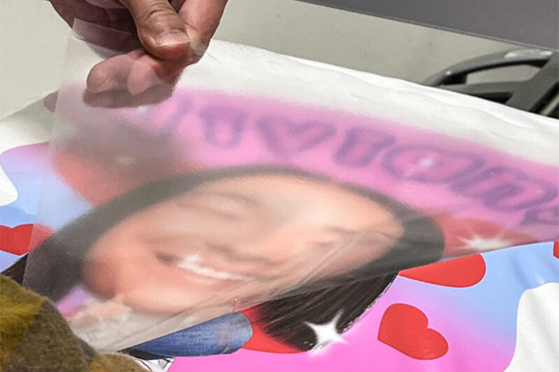 Hand peeling the film off the transferred design.