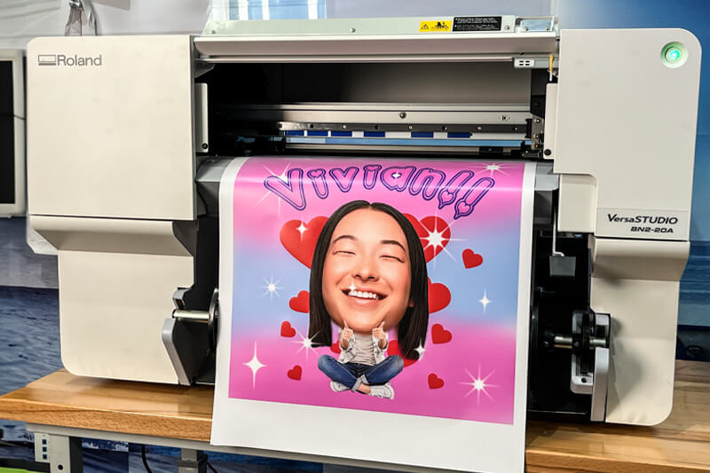 Roland DG VersaSTUDIO BN2-20 desktop printer/cutter printing the design.