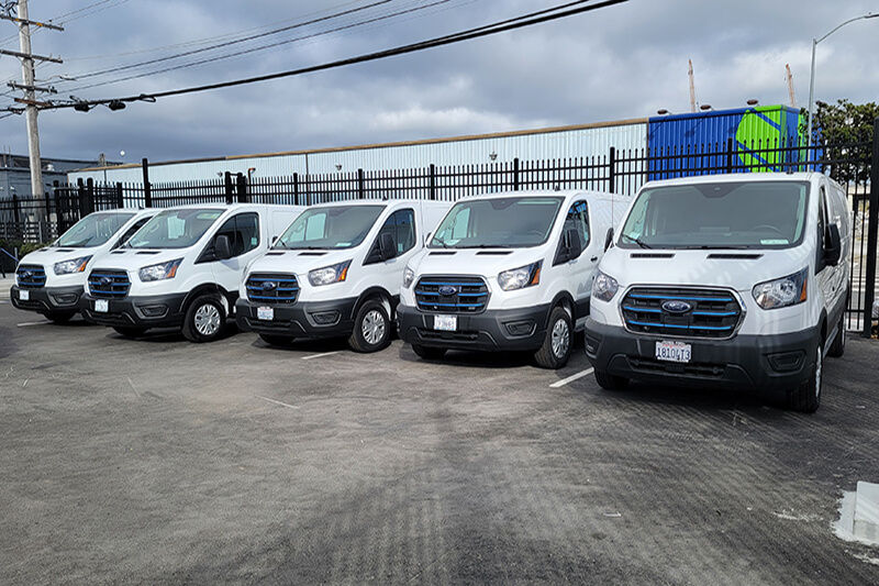 Five white vans awaiting fleet wrap installation