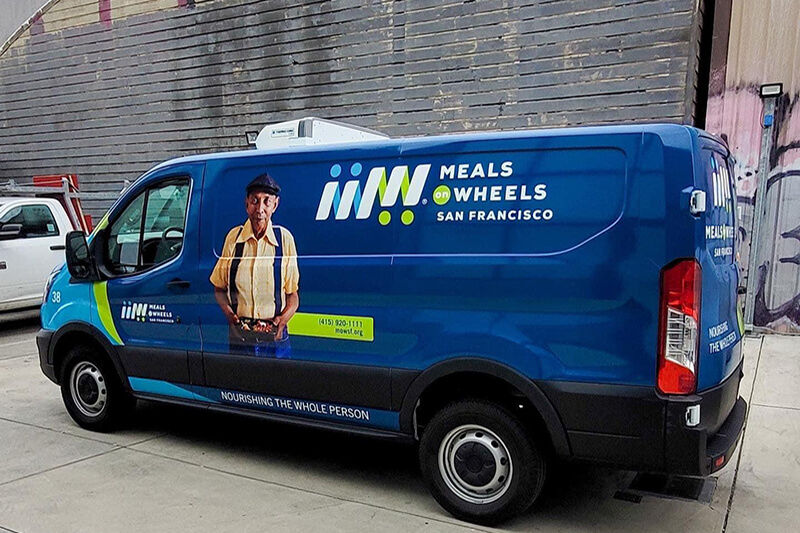 Vista lateral de furgoneta con gráficos de Meals on Wheels instalados