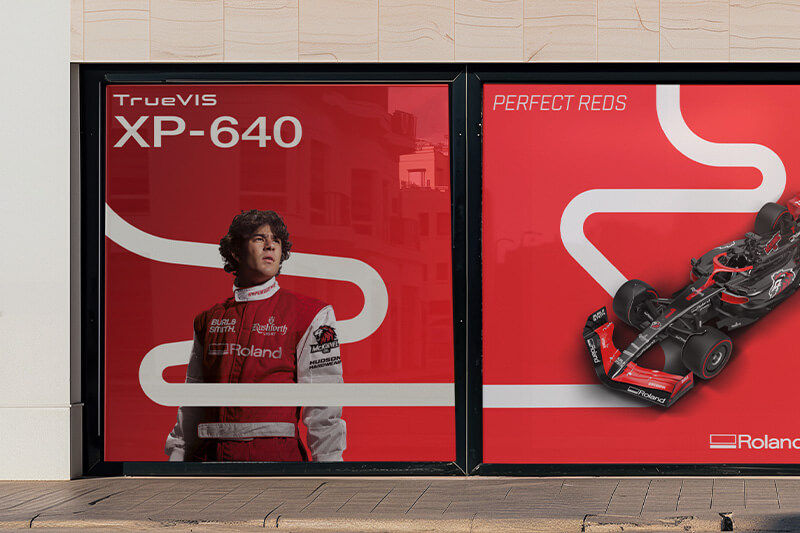 Windows with colorful vinyl graphics of a race car driver and drag racer.