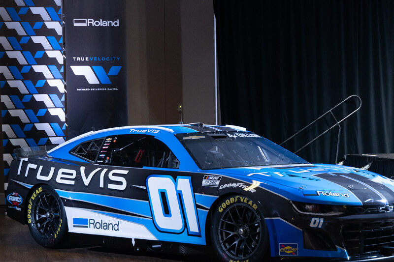 Blue, white and black vehicle graphics on a race car.