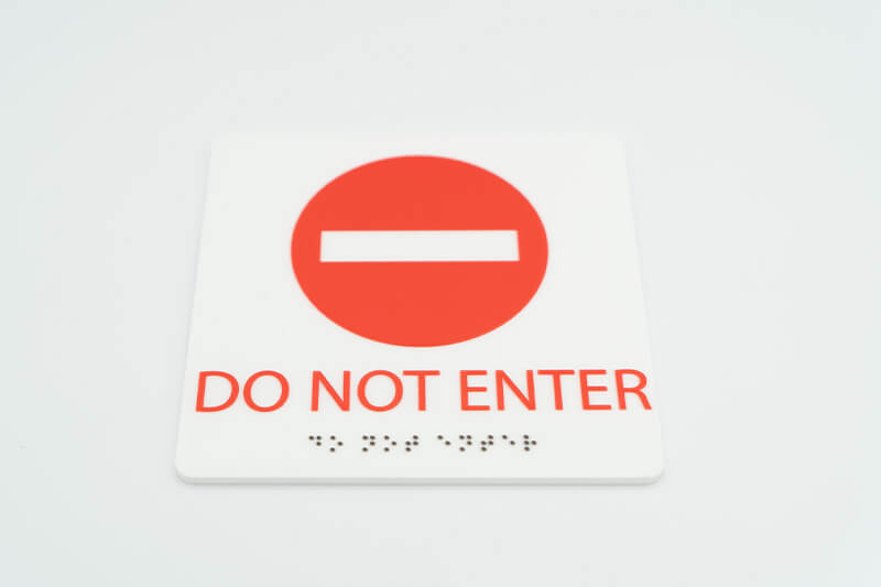 Letrero de "No Entrar" con texto braille.