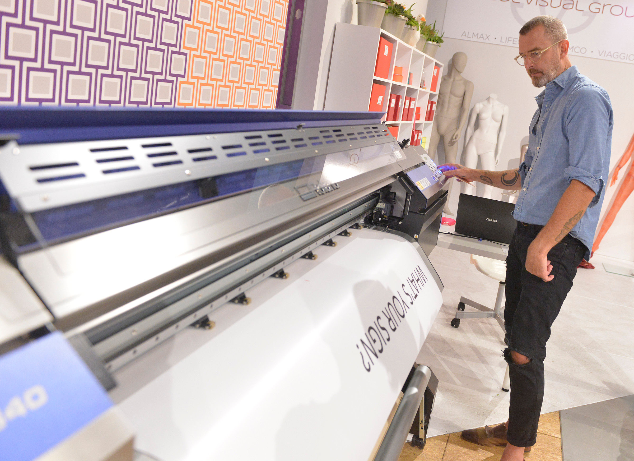 Timothy Howe, winner of Window Warriors season one, using a Roland printer on the set