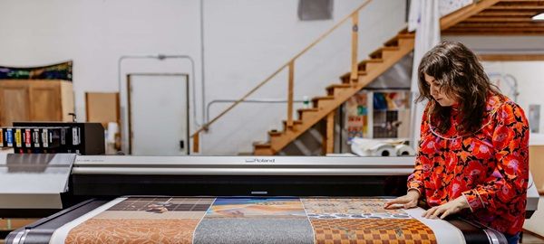 Imagen de Kathryn Sanders, Fundadora y Presidenta Ejecutiva de Western Sensibility, en su estudio usando una impresora UV de Roland DG.