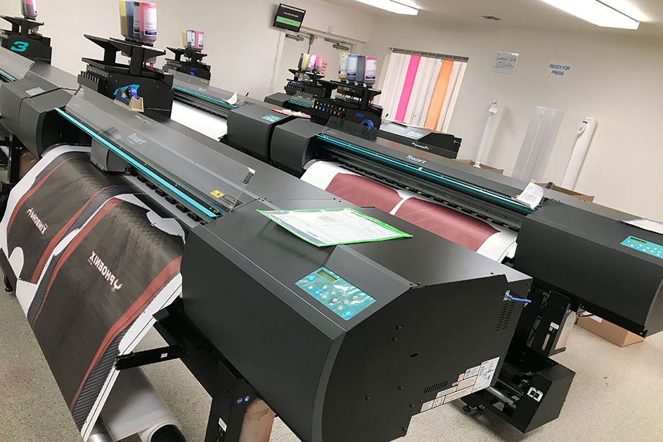 Roland dye-sublimation printers in Savi Customs' production room