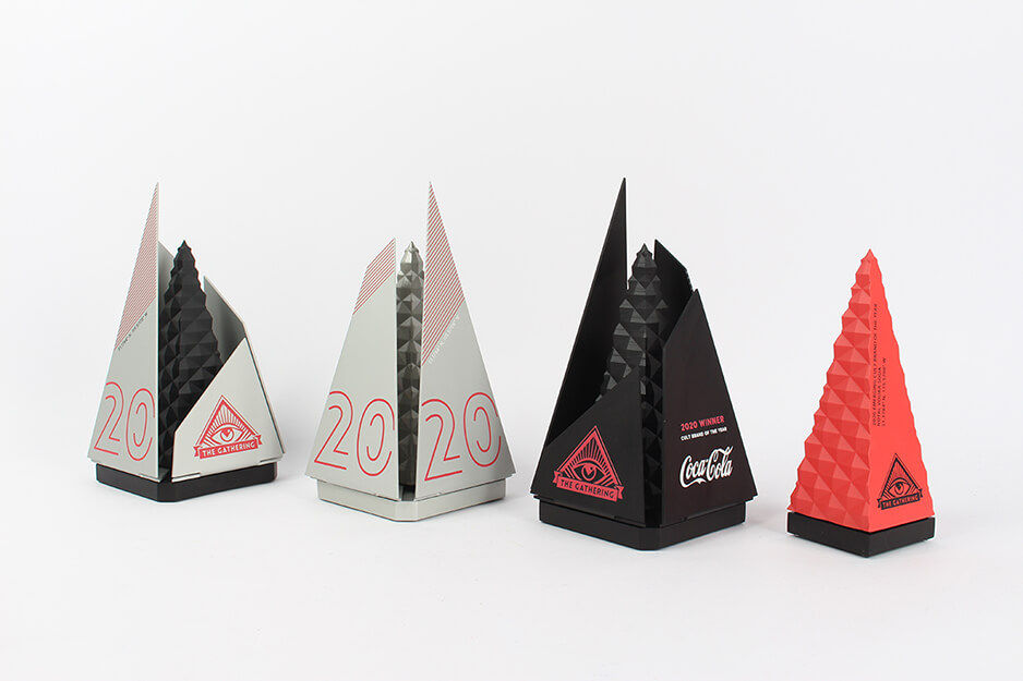 Galardones corporativos en forma de pirámide, en plata, negro, naranja y rojo para Coca-Cola. 