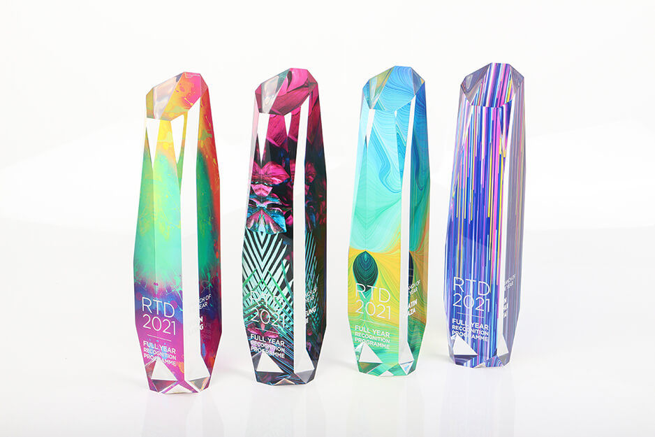 Four rainbow-colored acrylic pillar awards