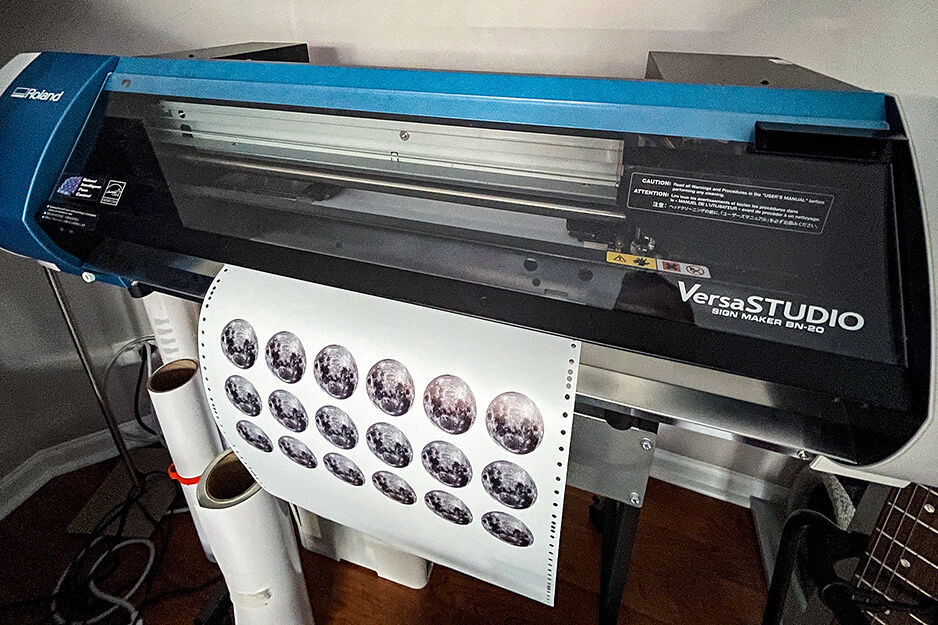 Arteehub's Roland DG VersaStudio BN-20 printer is shown printing rows of colorful custom decals.