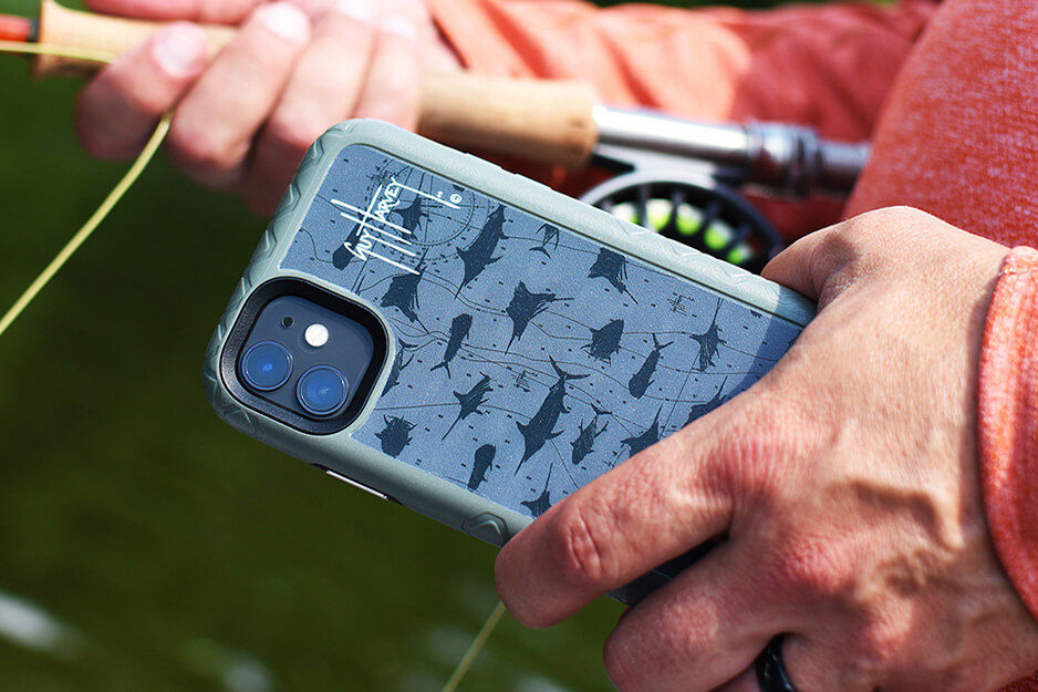 Fisherman's hand holding a phone case with grey and blue shark design, printed on a Roland DG VersaUV LEF2 printer