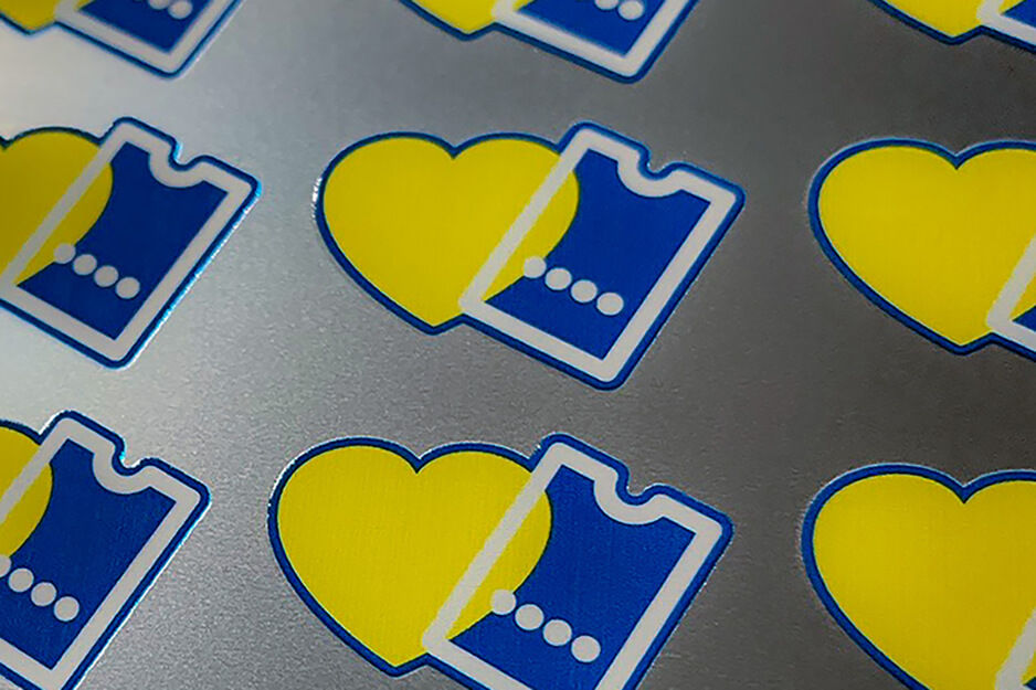 Custom printed pin designs with a yellow heart and a blue ticket