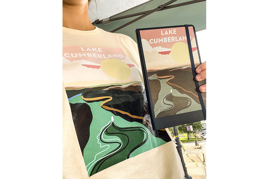 T shirt graphics worn by a woman holding matching graphics printed on journal