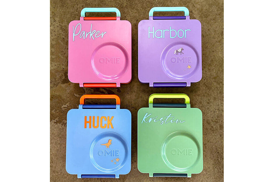 Four colorful square lunch boxes with custom printed names