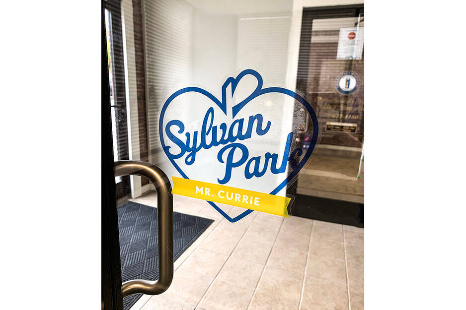 Door leading to entryway with blue and gold window graphics for "Sylvan Park"