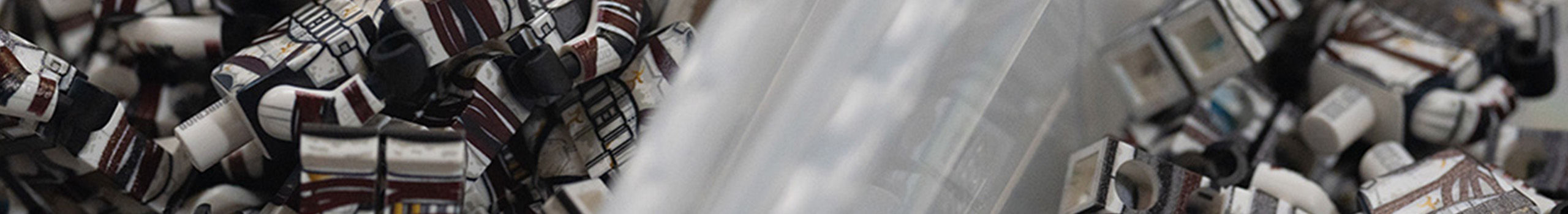 Mini figurines in bins awaiting customization.