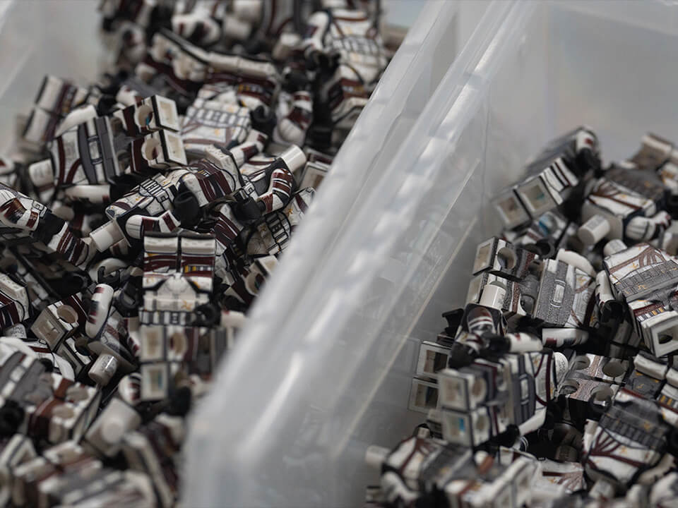 Mini figures in bins awaiting customization.