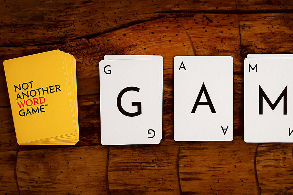 Four stacks of playing cards for game "Not Another Word Game" on wooden surface