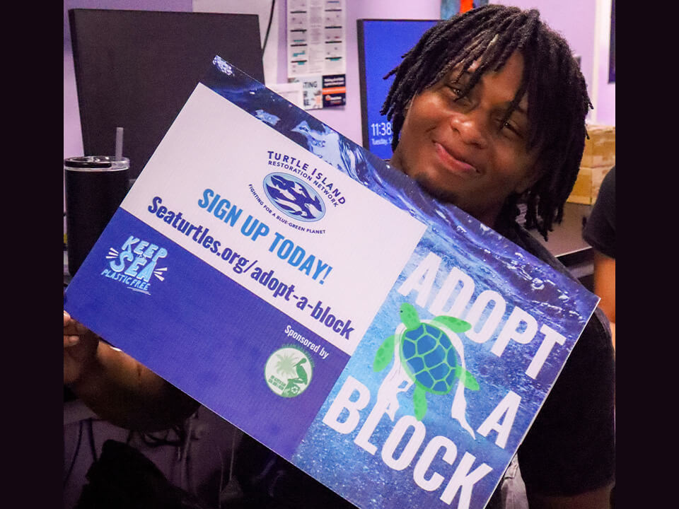 Ball HS Tor Store student holding sign that says Adopt a block