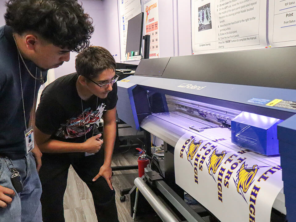 Ball HS Tor_Slider Image_Tor Store students reviewing output from Roland DG printer/cutter.