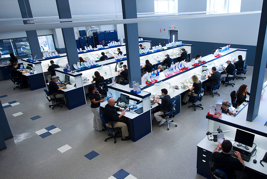 Interior of the Maverick Dental Laboratories facility where technicians inspect milled dental restorations produced on their fleet of Roland DGSHAPE DWX-52DCi dental milling machines.
