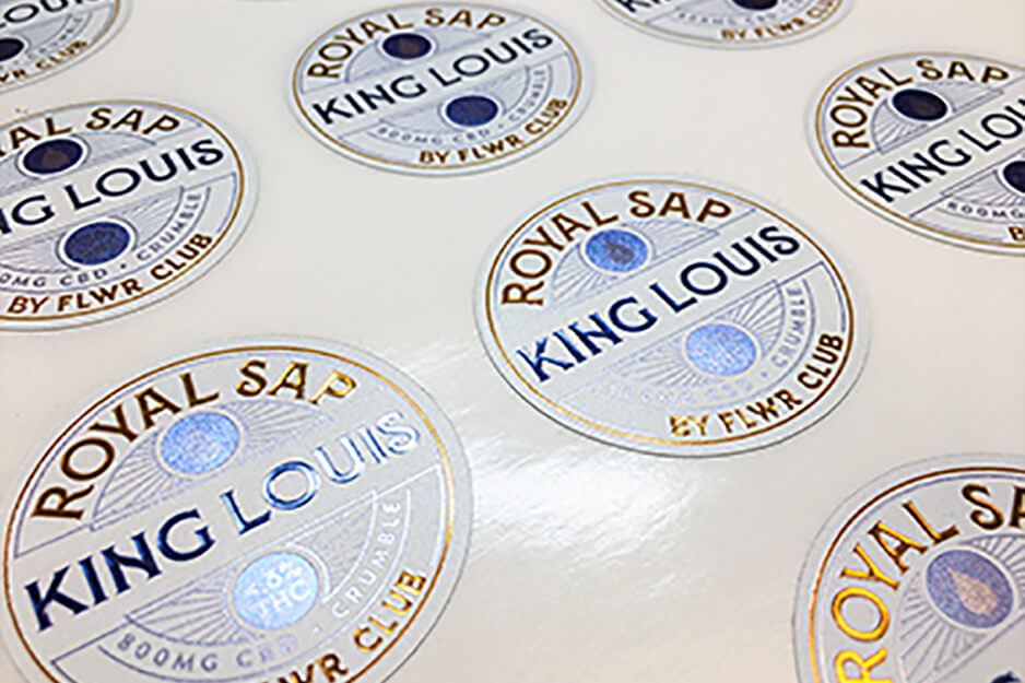 DMS Color produced these gold and blue on white round labels using its Roland DG VersaUV LEC2-300 UV printer.