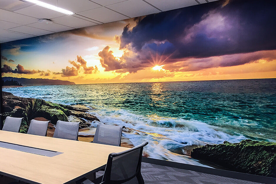 Vibrant ocean sunset wall graphics in a conference room.