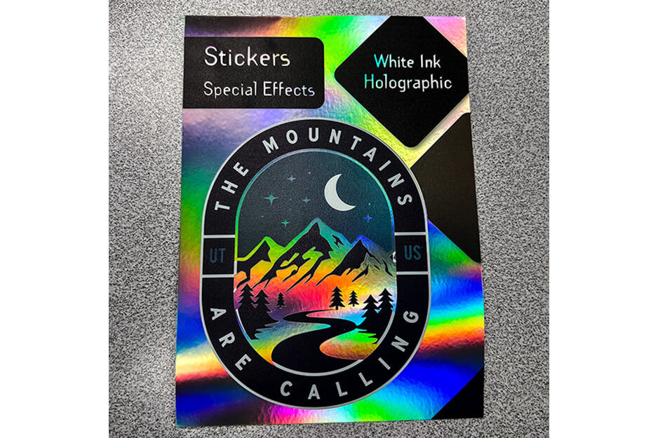 Holographic print with mountain scene and words "the mountains are calling."