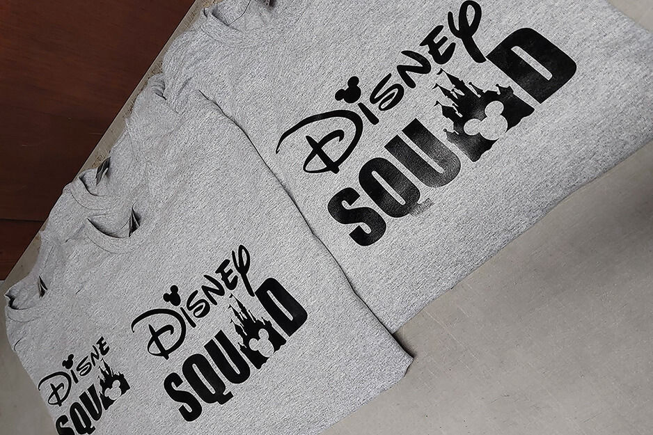 Grey folded shirts with the words "Disney Squad" printed on them