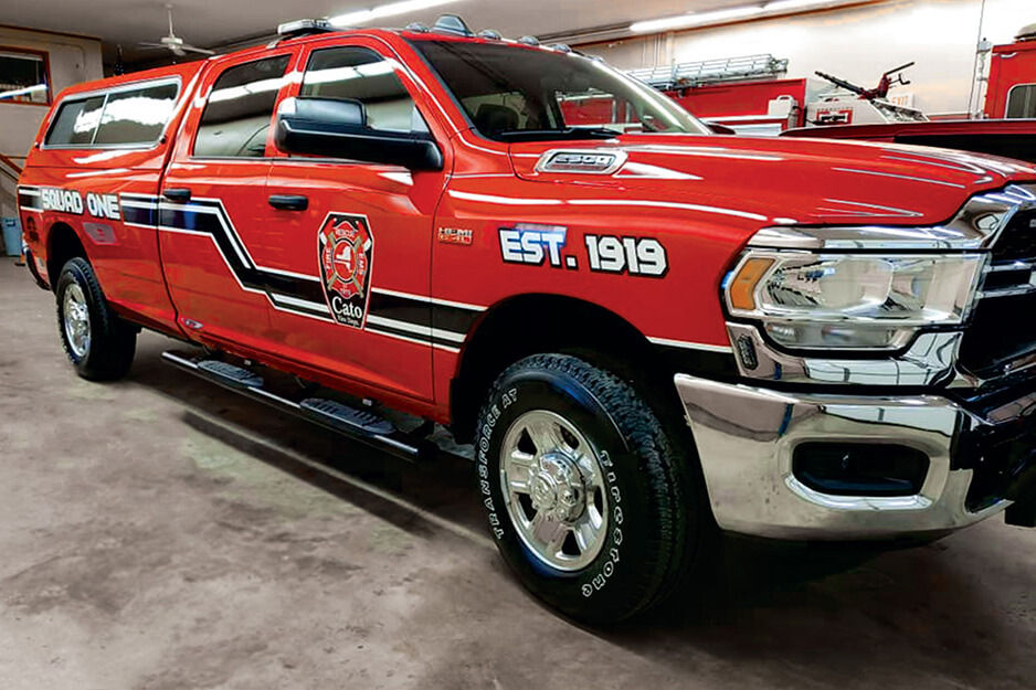 Red emergency vehicle with view of vehicle graphics along the passenger side.