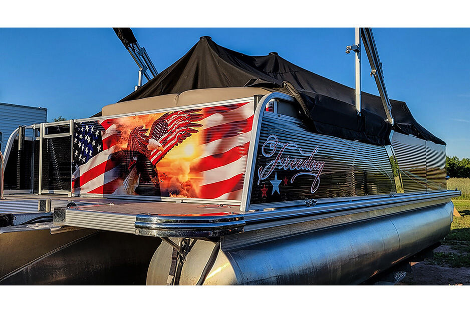 View of back and side of pontoon boat with patriotic graphics.