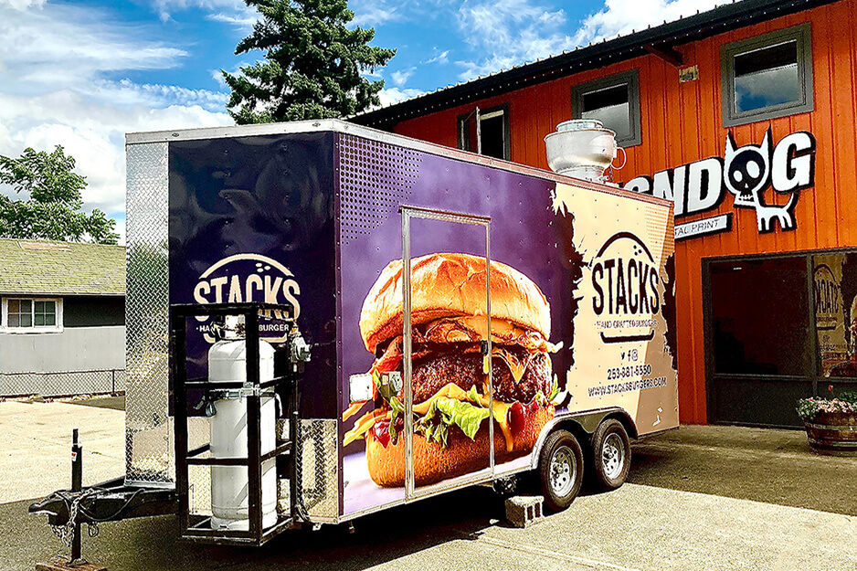 Stacks Burger trailer wrapped in colorful graphics parked in front of SignDog storefront