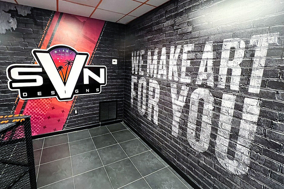 Corner of empty room with SVN Designs logo printed on one wall, "we make art for you" on the other wall.