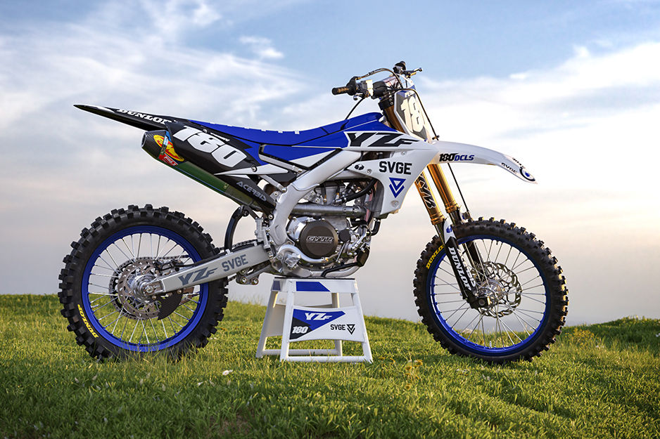 Motocross racing bike with blue and white graphics in a field of grass