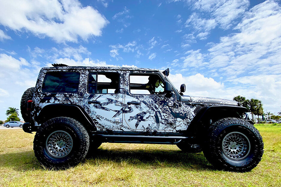 A side view of a jeep wrapped with camouflage graphics printed on Inked Vinyl's Roland DG TrueVIS VG2-640 wide-format printer-cutter.