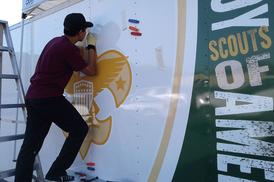 Student installs graphic on trailer