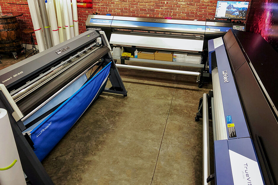 The production area at Z7GFX is anchored by three Roland DG devices, including a TrueVIS VF2 printer/cutter.